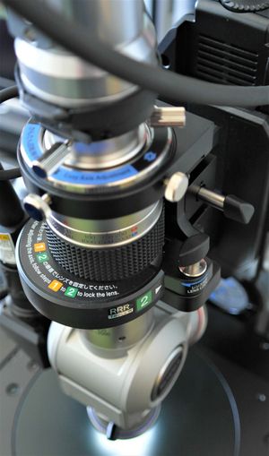 The dual swinging objective with 20 - 200× and 200 - 2000× magnification attached to the corresponding mount are shown.