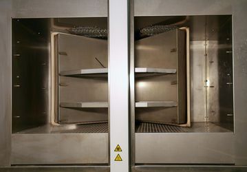 Picture of the temperature shock test chamber TSK 200 with opened doors and sample cabin in middle position is shown.
