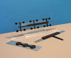 Samples of hybrid injection molding on glass and metal. There are three samples with molded black plastic on glass and metall with a excellent adhesion.