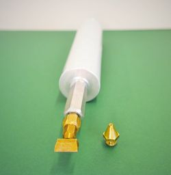 Picture of a round and a slotted nozzle (mounted on a cartridge) of the hot-melt gun TR 70 is hown.