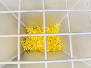 The picture shows the view into the granules funnel from the main dosing device. Golden granules are on the ground of the funnel.