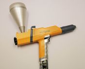 The hand-held gun for powder coating is shown.