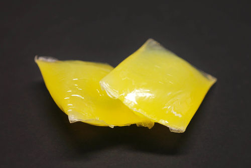 Das Bild zeigt Schmelzklebstoff in Kissenform. Es sind zwei gelbe Kissen abgebildet.