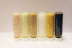 Picture with a selection of plastic granules in glass bottles.