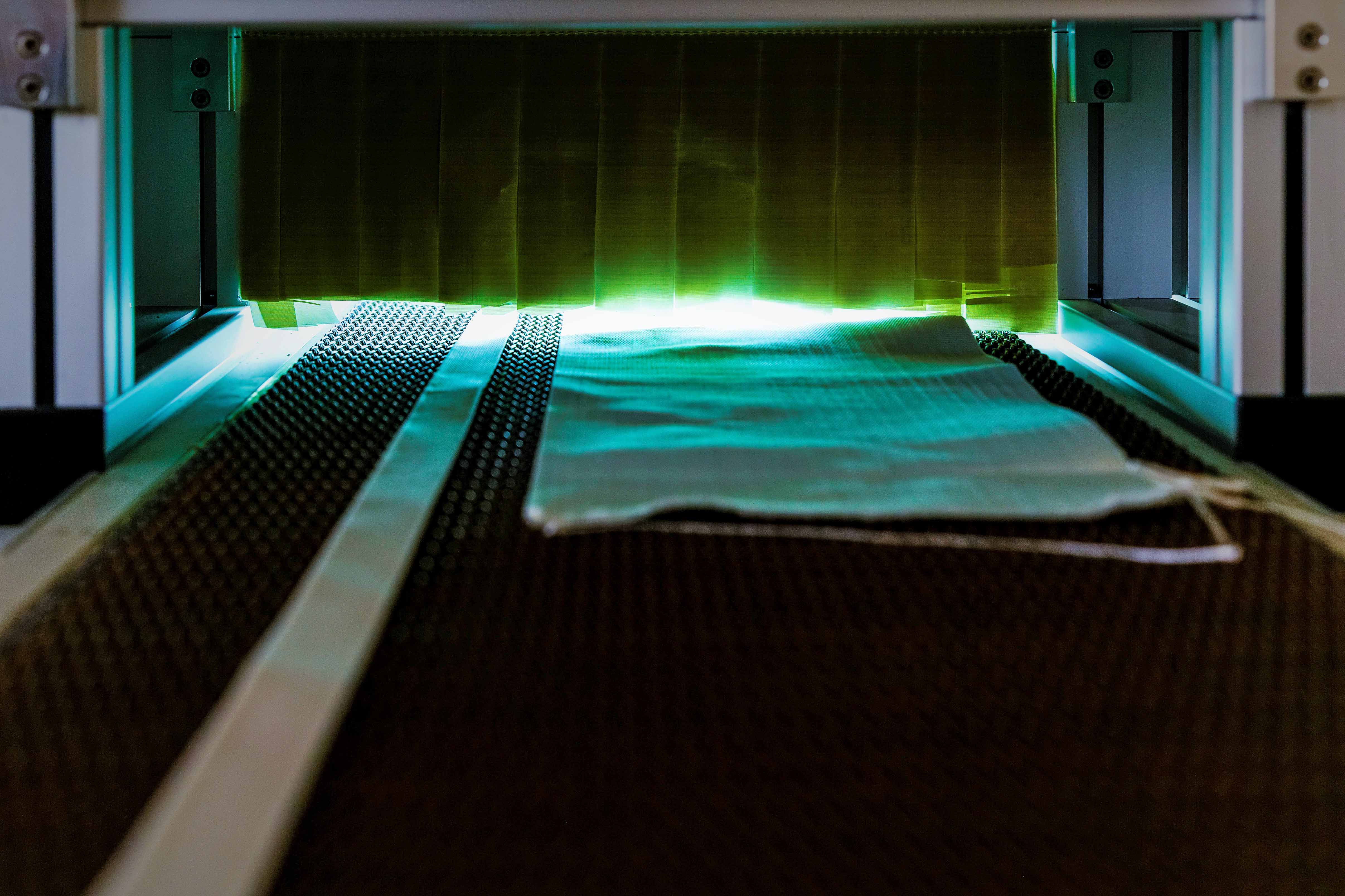 textile Gewebe beim Durchlauf der NIQ-Bestrahlungseinheit