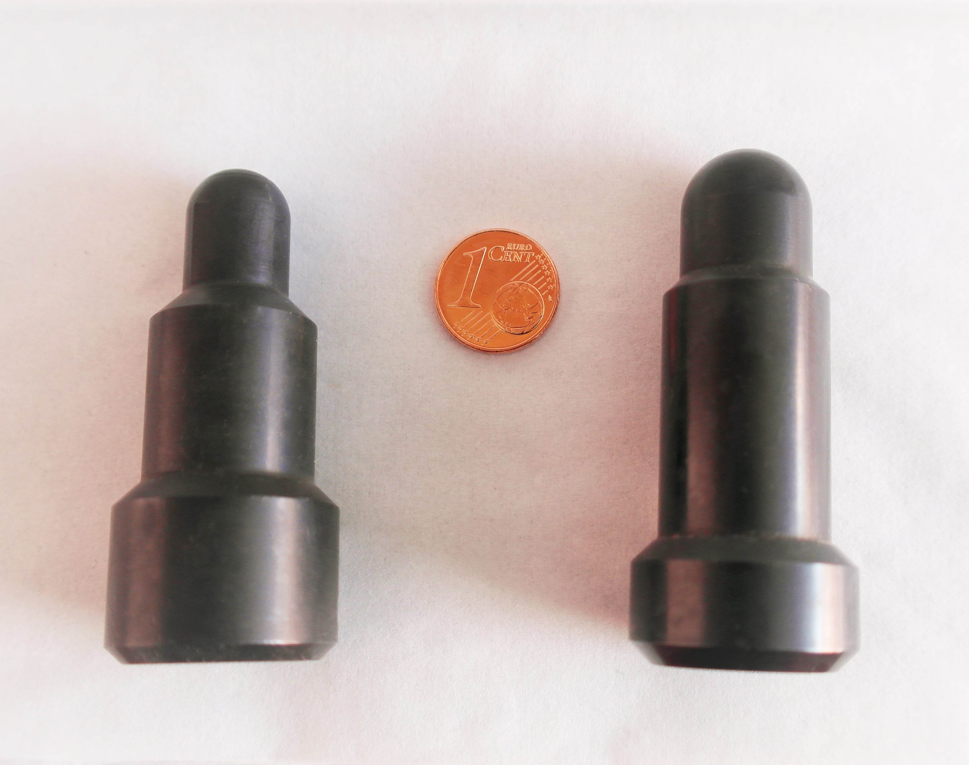 Die Abbildung zeigt zwei unterschiedliche Prüfstempel im Größenvergleich mit einem 1 Euro-Cent Stück. Der dünnste Teil der Prüfdorne ist rund hat ungefähr den Durchmesser der Münze.
